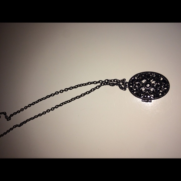 Long necklace with a decorated oval that opens