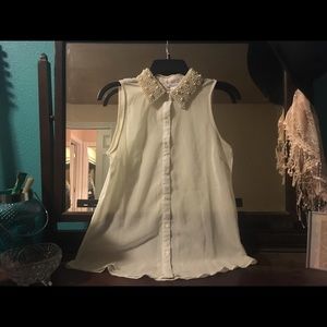 Cream sleeveless tank with pearl beaded collar.
