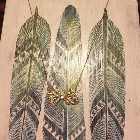 Gold tone and crystal bow necklace. Long.