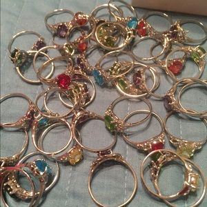 Assorted silver rings with colored stones .