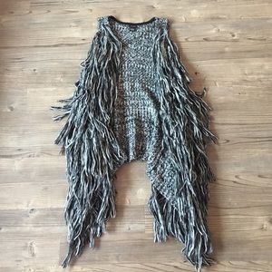 Grey-knitted, fabric-tied, sleeveless shawl.