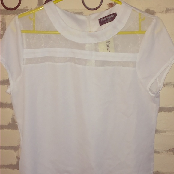 White blouse with sheer paneling on top.