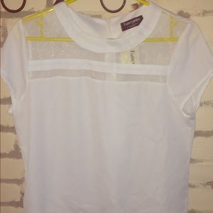 White blouse with sheer paneling on top.