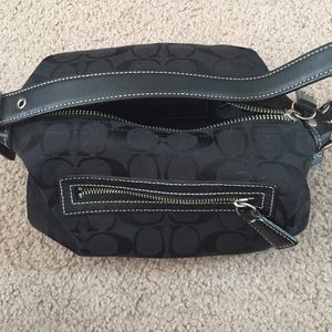 Black coach bag zips shut leather strap