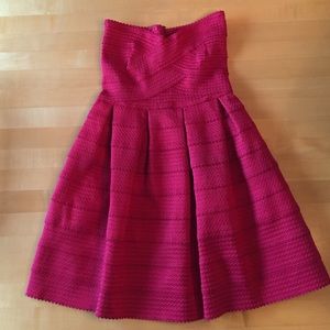 Reddish/pink strapless dress.