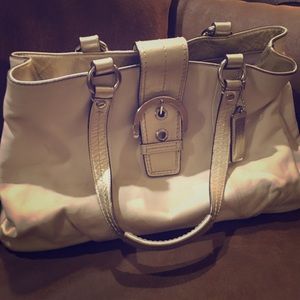 White and gold coach handbag.