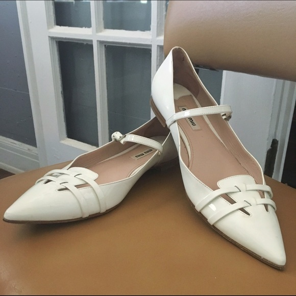 White patent leather pointed toe flats by Miu Miu