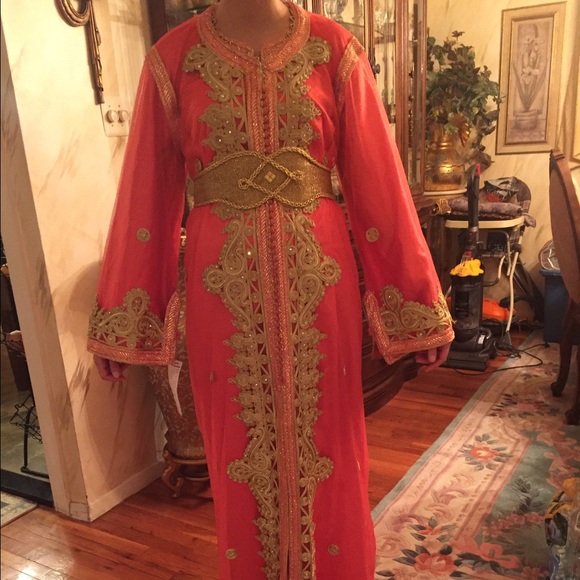 A beautiful moroccan kaftan , orange and gold .