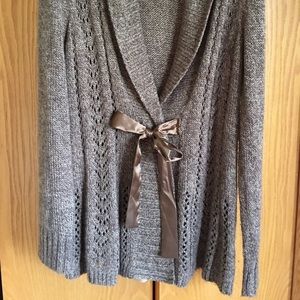 Sweater with snap closure and ribbon on front