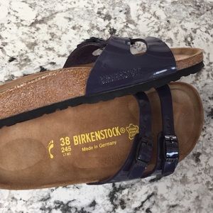 Plum shiny Birkenstock sandals.