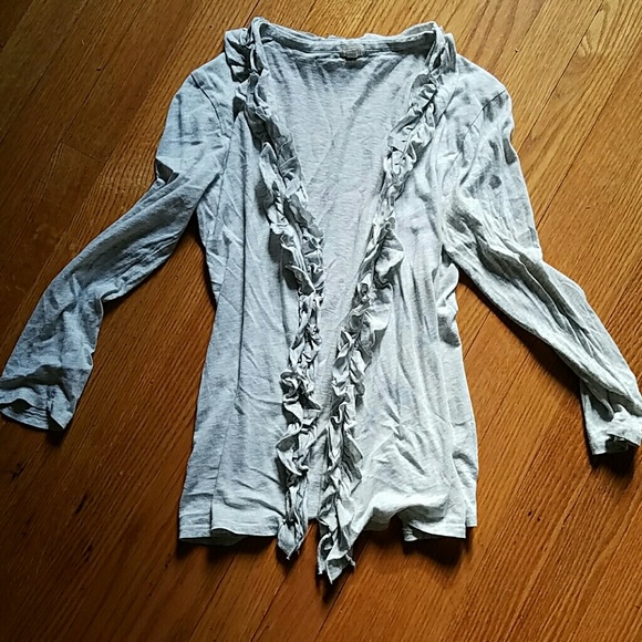 Light gray cardigan with ruffles.