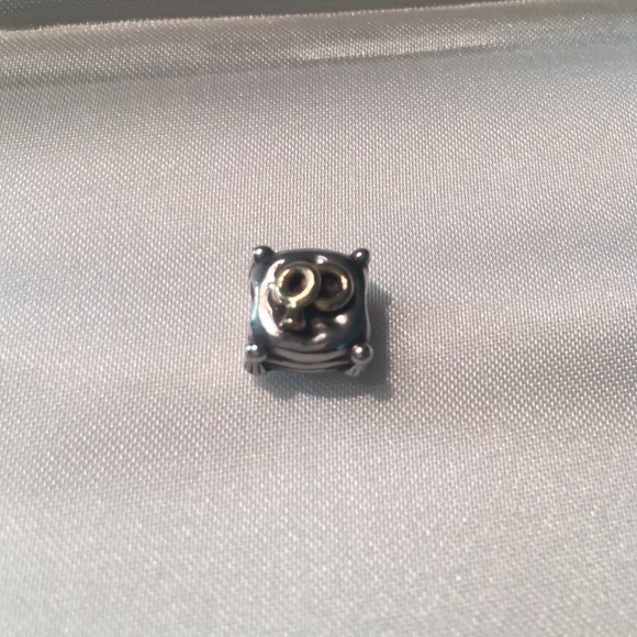 Pandora gold tone wedding rings on pillow charm.