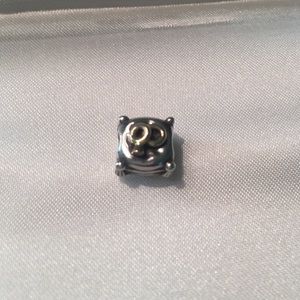 Pandora gold tone wedding rings on pillow charm.