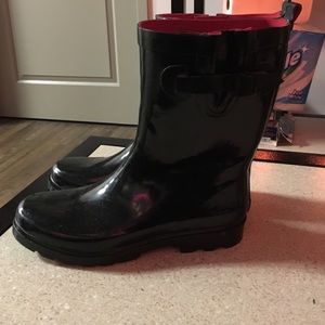 Black rubber rain boots with red inside.
