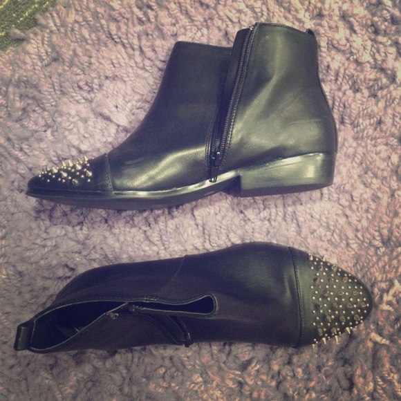 Black ankle boots with spikes on the toes.
