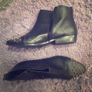 Black ankle boots with spikes on the toes.