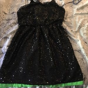 Black sequin dress w/ green stripe at the bottom.