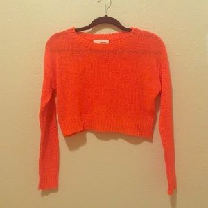 Bright orange crop top sweater.