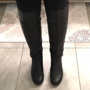 Knee-high black boots with gold studs