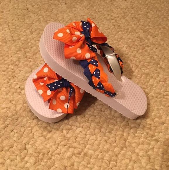 White flip flops with orange and blue embellishments