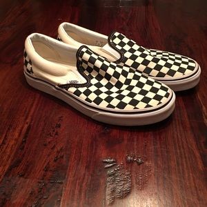 Pair of black and white checkered Vans shoes.