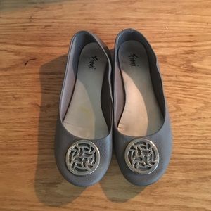 Gray flats with a silver design on the front.