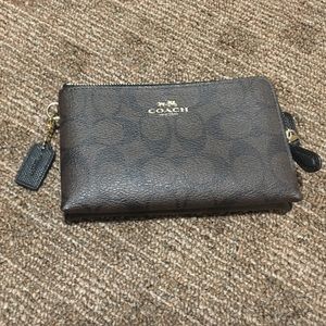 Dark brown and black signature Coach wristlet.