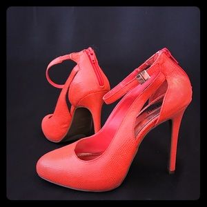 Jennifer Lopez orange pumps with ankle strap.