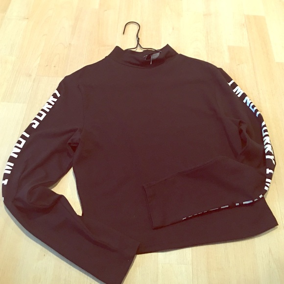 A black crop top with letters along the sleeve