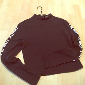 A black crop top with letters along the sleeve