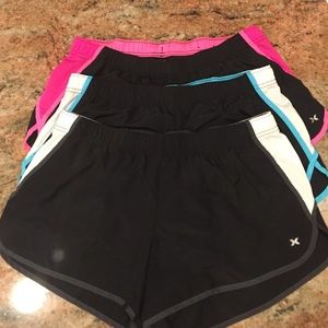 Three pairs of Women's Xersion workout shorts.