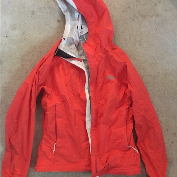 Salmon orange colored north face rain coat