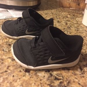 Black Nike infant sneakers with velcro.