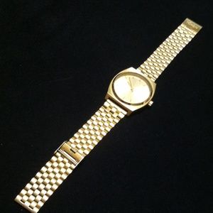 Gold Nixon time teller watch