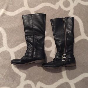 Black riding boots with buckles and zippers.