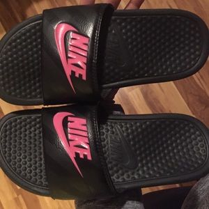 Black Nike slides, pink Nike font