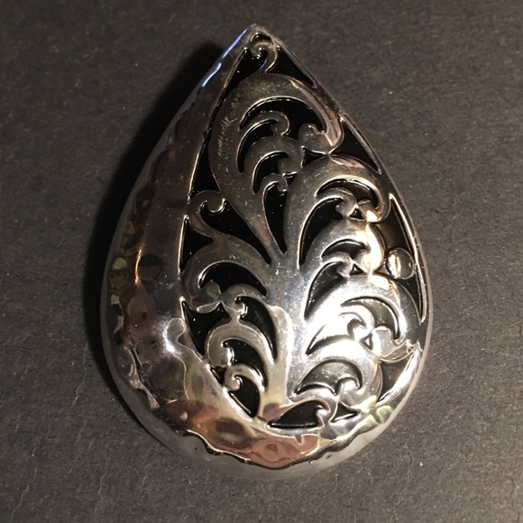 Silver tone Pendant Design with black behind it