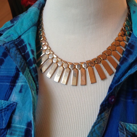 Gold, metalic bib necklace with graduated rays.