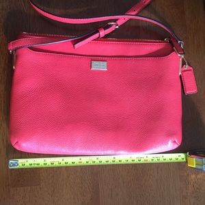 A orange - red Coach cross body bag.
