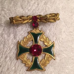 Vintage brooch with cross emblem.