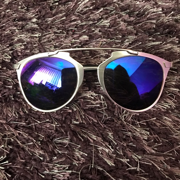 Black and gold sunglasses with purple tint.