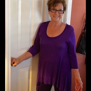 Purple tunic, shark-bite hem.