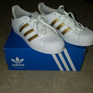 Gold striped Superstar Adidas sneakers