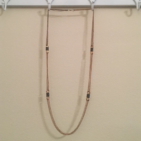 Long gold necklace with gray jewels