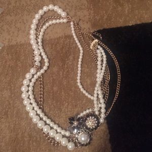 Pearl necklace with gold and black trim.