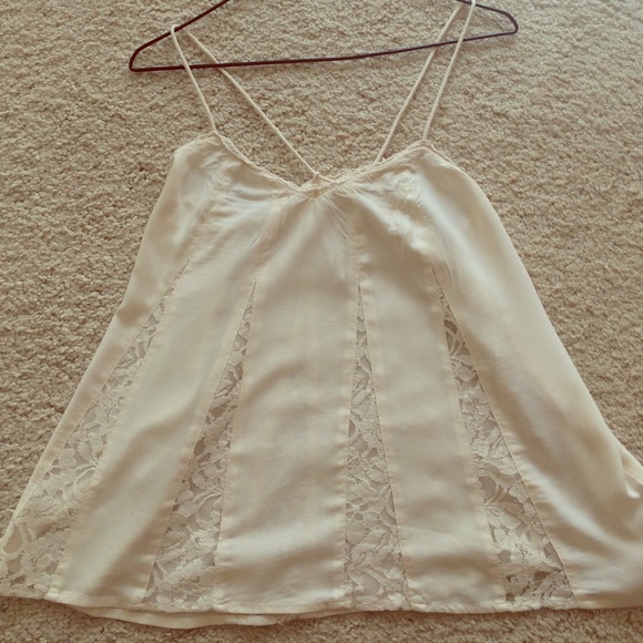 A beautiful sheer cream tank top with lace detail.