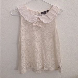 Lace sleeveless blouse with Peter Pan collar.