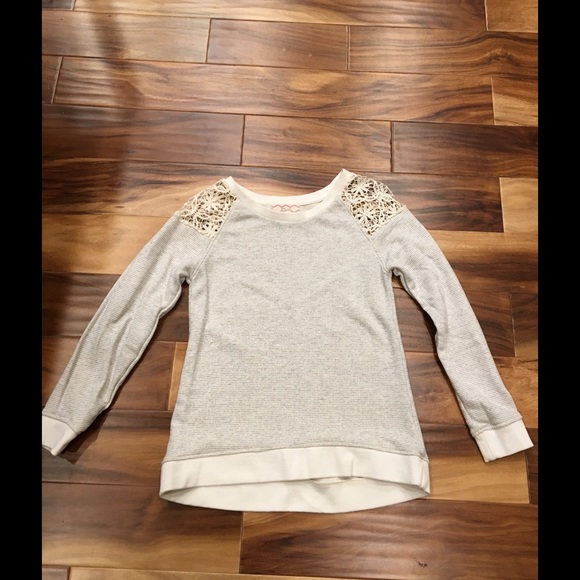 Cream colored top with lace shoulders.