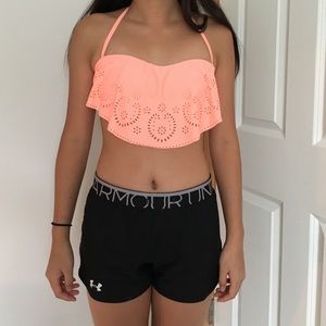 a coral swimsuit top with flower like cut outs