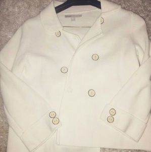 White coat with black buttons. Half way sleeves.